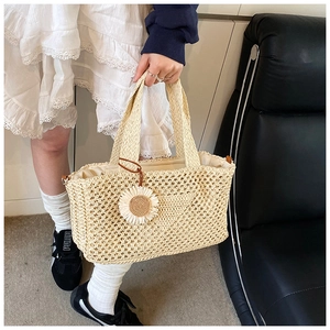 Détail du sac en paille tissé à la main avec pendentif fleur blanche et doublure