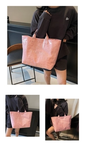 Detailansicht der rosa glänzenden Tragetasche mit weißem TOTE BAG Aufdruck und Griffen