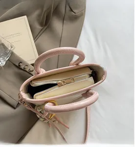 Détail de la fermeture à glissière supérieure de ce sac seau crème et rose