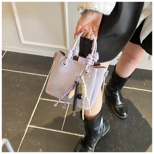 Détail du sac seau violet clair avec poignée en corde épaisse et glands tissés colorés