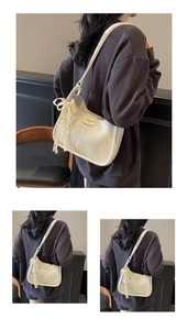 Close-up of litchi texture leather bag with lace bow and pearl charm detailing