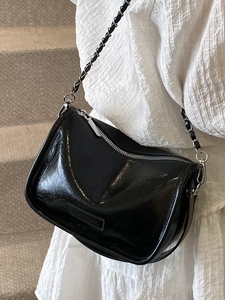 Trendy black glossy pleated pillow bag with metallic chain and stylish curved zipper design