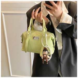 Close-up of lime green patent leather Boston bag featuring pearl and cartoon charms