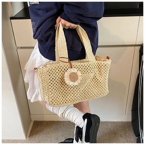 Détail du panier en paille tissé main avec charm tournesol pour vacances d'été