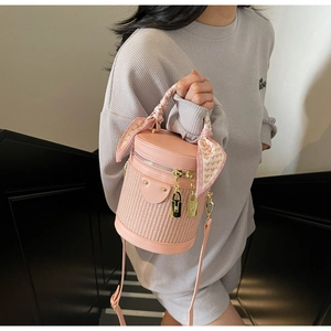 Pink cylinder bag detail with heart print scarf handle and gold lock zipper