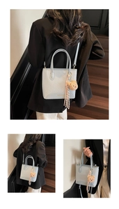 Detail of woven texture bucket bag with detachable strap and plush bear charm