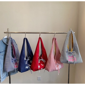 Detail view of large canvas tote bags in various colors with bow drawstring details