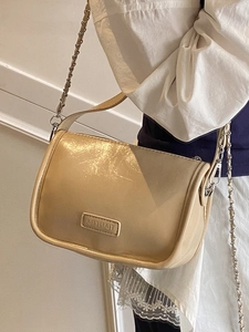 Minimalist beige glossy leather pillow bag with metal chain strap for daily commute