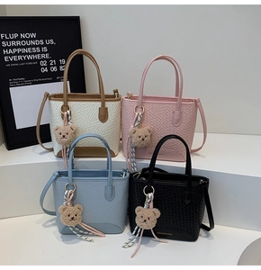 Matrix view of woven leather bucket bags in white, pink, blue, and black with bear charms