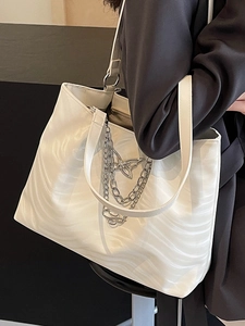 Minimalist white tote bag with wave texture and silver butterfly chain on model