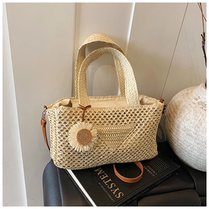 Détail du sac panier en paille avec charme tournesol et bandoulière en cuir marron