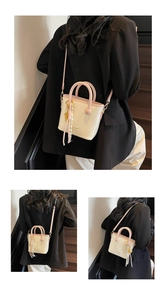 Détail du sac seau crème avec poignées roses, logo et foulard décoratif à pois blancs