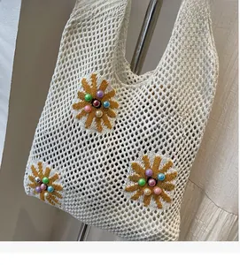 Detail of crochet tote bag featuring yellow sunflower patterns and colorful bead accents