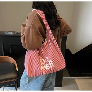 Detail of red and white striped tote bag with be well print and wide shoulder strap
