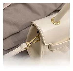 Detalle de ganchos de metal dorado de alta calidad y cuero acolchado blanco en el bolso