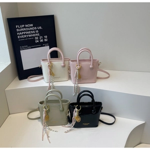 Détail de quatre sacs seau colorés avec des breloques en forme de raquette de tennis