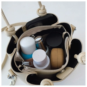 Gros plan du sac seau en cuir beige montrant sa grande capacité pour les essentiels