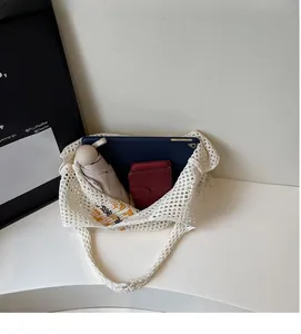 Spacious interior of white crochet tote bag holding an umbrella, tablet, and wallet