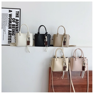 Détails des sacs seaux en cuir grainé de différentes couleurs sur des marches blanches