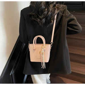 Détail d'un sac à main en cuir verni rose avec fini brillant et gaufrage de marque