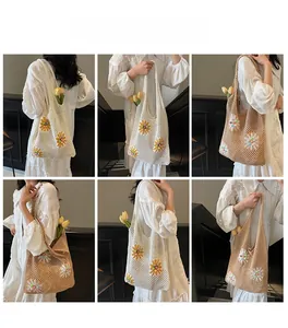 Detail of hand-woven hollow knit tote bag with colorful flower appliques and pearl accents