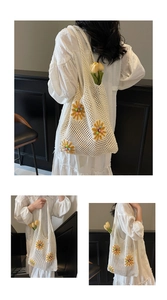 Detail of white crochet knit beach bag with yellow daisies and pearl bead accents