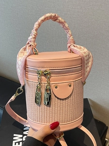 Pink cylindrical bucket bag with woven leather detail and silk scarf wrapped handle