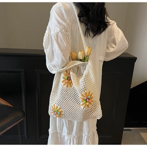 Detail showing hand-crocheted cream tote bag with sunflower embroidery and colorful beads