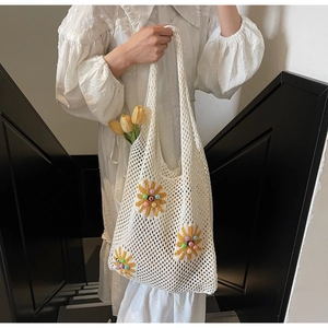 Detail of white crochet knit tote bag with yellow sunflowers and colorful pearl beads