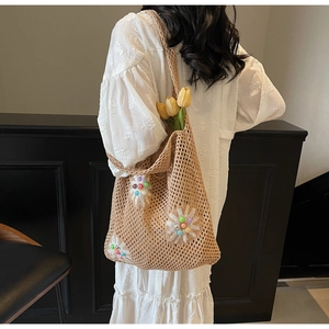 Detailed texture of beige crochet shoulder bag with colorful floral bead embroidery