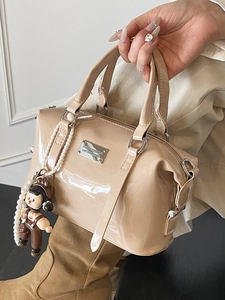 Glossy patent leather Boston bag in beige with metallic nameplate and pearl chain charm
