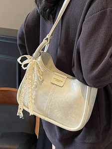 Minimalist cream shoulder bag with pearl bow pendant and pleated leather texture design
