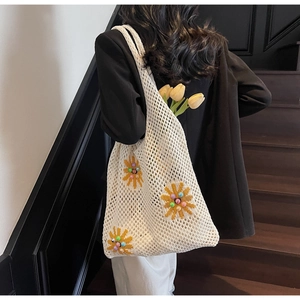 Detail of crochet tote bag with sunflower embroidery and colorful beads on shoulder