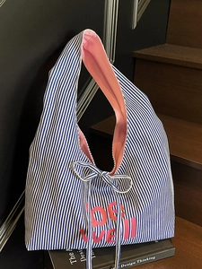 Blue and white striped canvas tote bag with pink be well print and bow tie detail