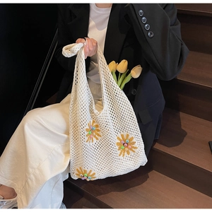 Detail of crochet knit tote bag with yellow sunflower embroidery and colorful bead accents