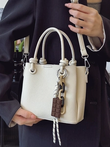 Sac seau chic en cuir crème avec breloque chocolat et détail de bandoulière tissée