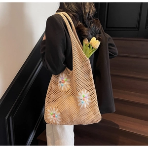Detail of beige crochet tote bag with 3D floral accents and colorful bead centers