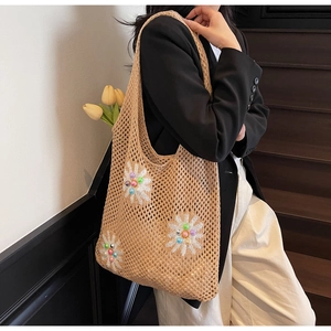 Detail showing hollow knit pattern and 3D white daisy floral beads on straw shoulder bag