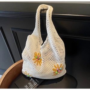 Detailed shot of white hollow knit bag with yellow daisy embroidery and colorful beads