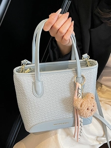 Light blue woven texture handbag with plush bear charm and pink ribbon decoration