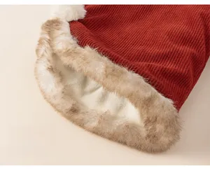 Detail view of red corduroy kids trousers with thick warm faux fur lining and loose cuffs
