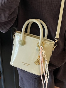 Sac seau chic en cuir verni vert clair avec détails dorés et breloque élégante