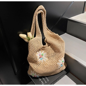 Detailed close-up of handmade hollow crochet tote bag with colorful beaded daisy flowers