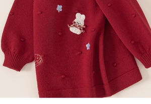 Close-up of red knit sweater with white 3D bunny patch and sweet bobble texture