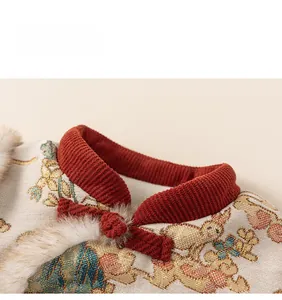 Detail of traditional Chinese knot button on red quilted jacquard fabric with fur trim