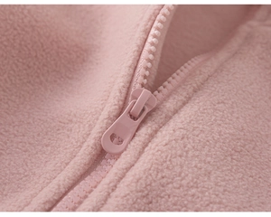 Close-up of pink polar fleece fabric texture and matching resin zipper for kids jacket