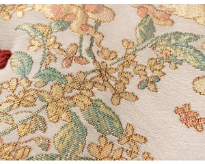 Macro detail of high-density floral embroidery with metallic gold silk threads
