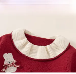 Detail of red knit dress featuring a white lace collar and cute rabbit patch with bow