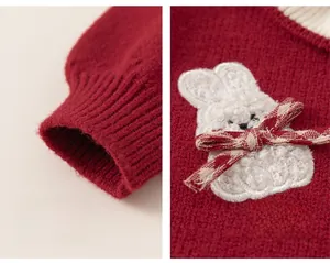 Detail of red knitted dress for girls featuring a cute plush bunny and ribbed cuffs