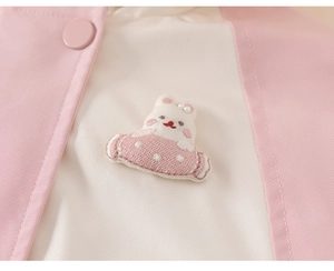 Detail of pink and beige winter toddler jacket with cute embroidered rabbit and pearls